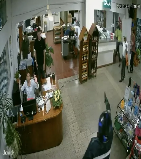 Hombre con casco y armado apunta al persona de un comercio de la zona Este de Salto el día 24 deoctubre de 2025 a las 11 de la mañana. / Imagen del video de seguridad de la empresa.