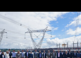 Salto Grande presentó proyecto ante la Unión Europea Group of professionals posing outdoors in front of large electrical pylons and a substation, with a green news banner reading 'NOTICIAS & NOVEDADES' and the EL PUEBLO logo in the corner.