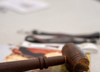 Remate Select finalizó con colocación total Close-up of a wooden gavel in the foreground with a green news banner announcing 'Remate Select finalizf3 con colocacif3n total' and a small author photo on the side.