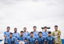 Consumado avance al Mundial ¡Cante, Uruguay!: 3-0 Uruguayan men’s soccer team posing for a group photo on the field in light blue jerseys, goalkeeper in yellow, in front of a news-style banner.