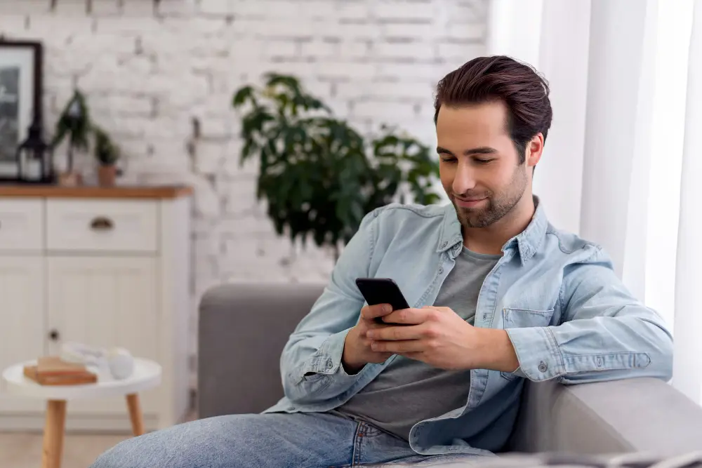 Hombre jóven observando su teléfono celular