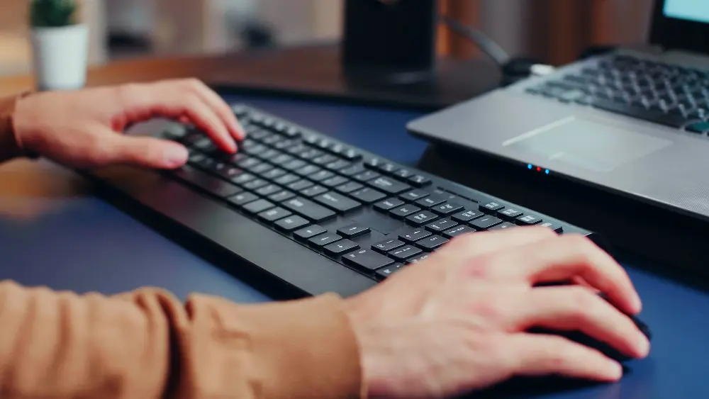 Primer plano de un una persona trabajando con un teclado